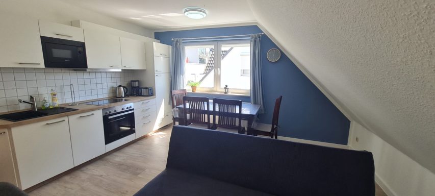 Wohnzimmer mit Küche, Couch und separatem Eßtisch