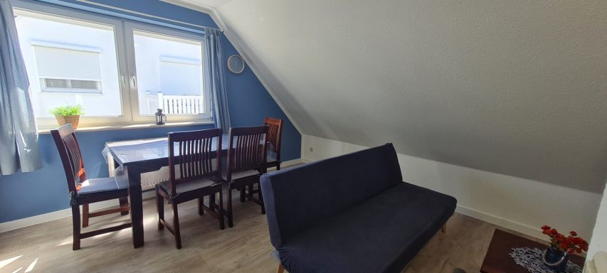 Wohnzimmer mit Couch und separatem Eßtisch